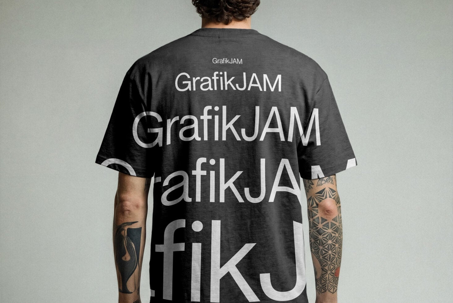 Charcoal tee showing overlapping GrafikJAM text on back