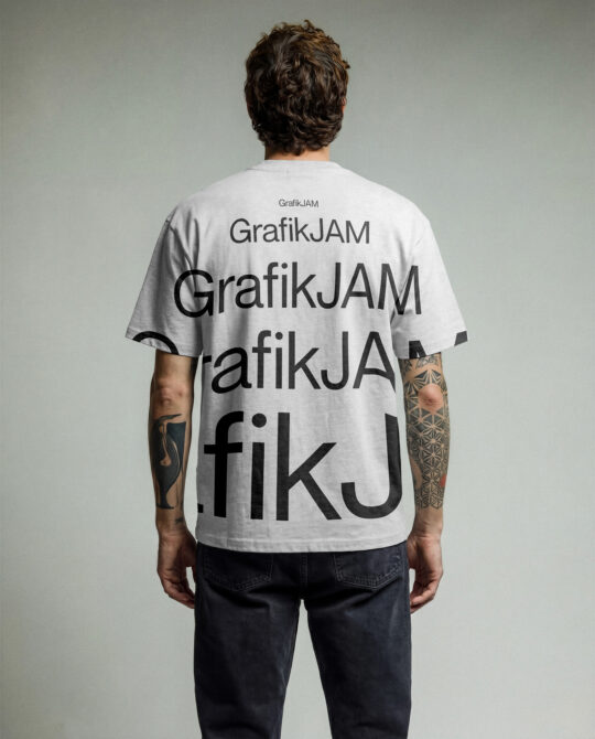 Back view of cream tee with repeated GrafikJAM text pattern across shirt