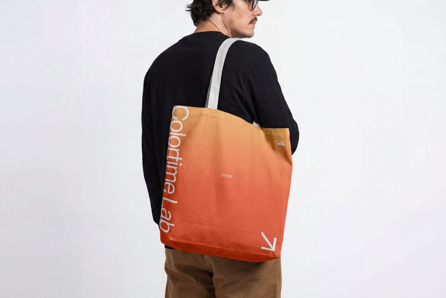 Gradient orange tote bag worn on person's back with white strap visible