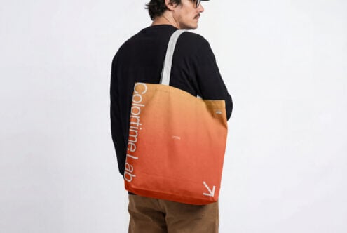 Gradient orange tote bag worn on person's back with white strap visible