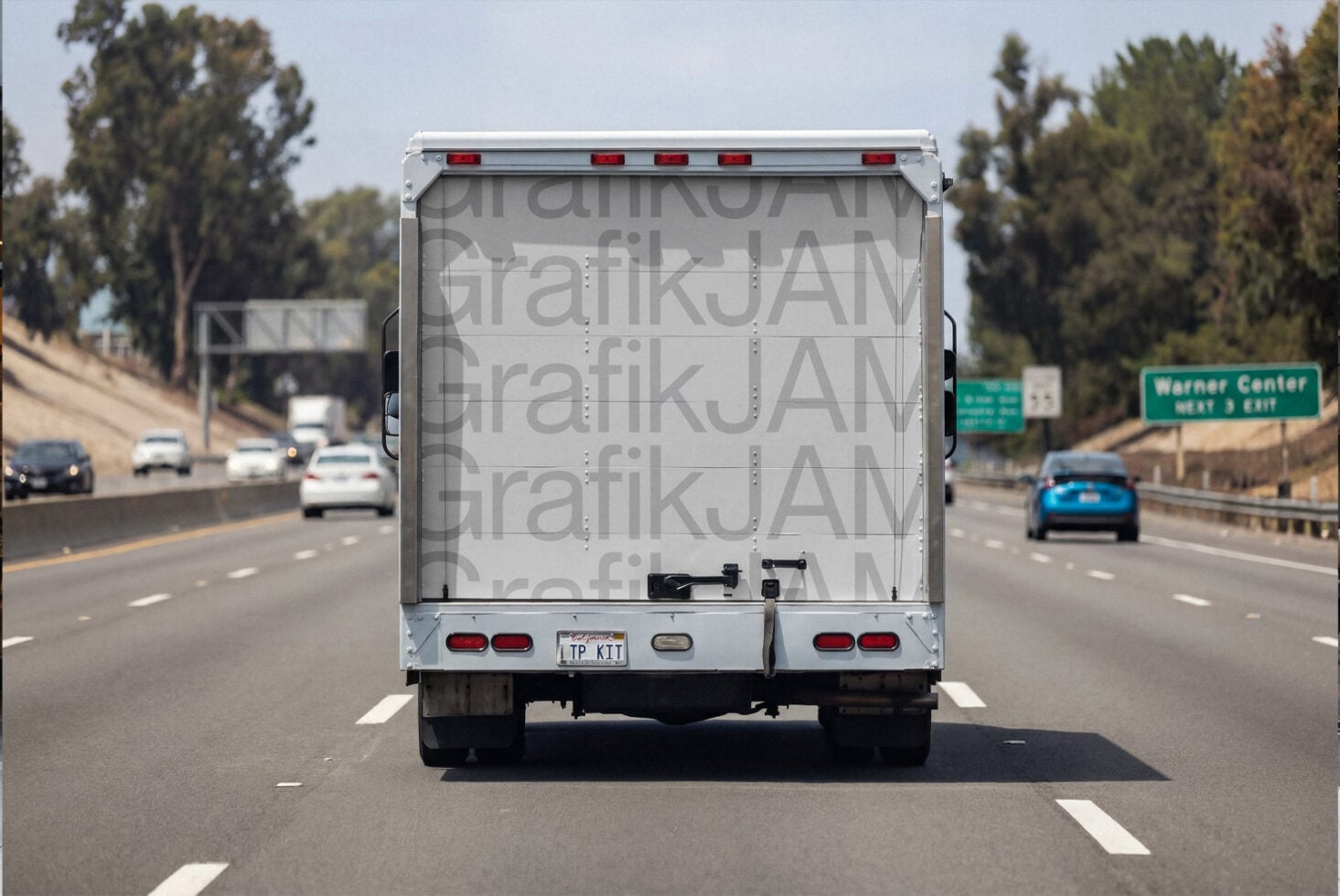 Truck rear on highway showing light gray repeated text wrap design