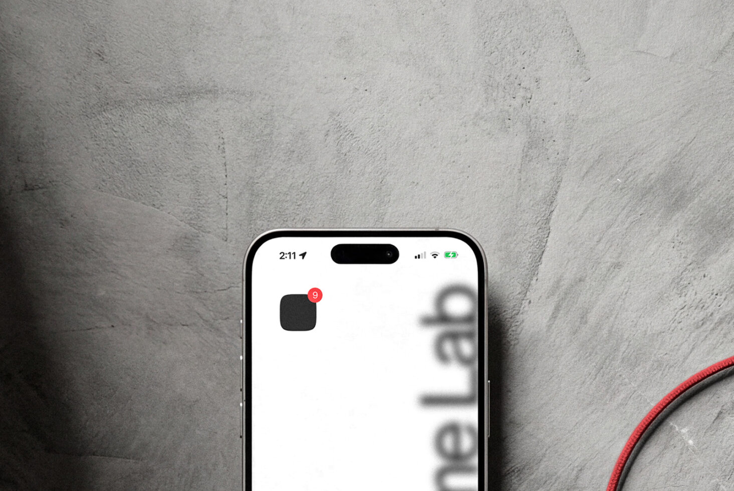 iPhone home screen with app icon showing red notification badge on concrete