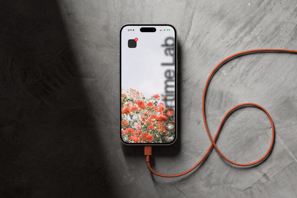 Light iPhone mockup with red flower photo on screen, matching red USB-C cable coiled nearby