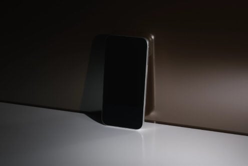 Smartphone mockup with blank black screen, chrome edge, minimal setup shot