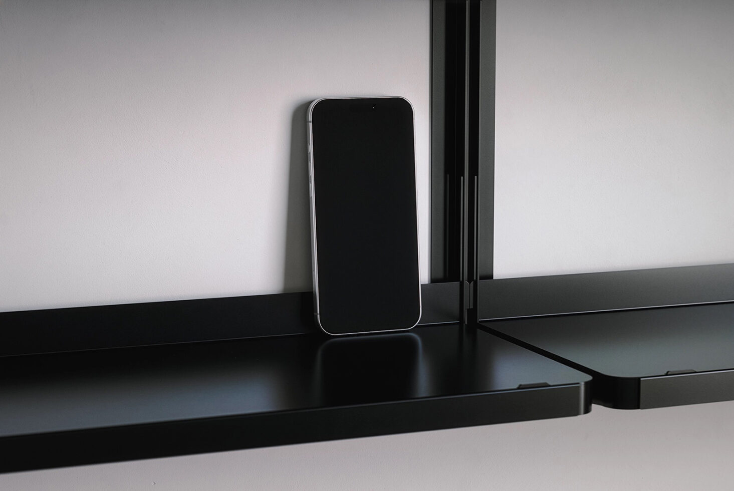 Smartphone on black desk standing empty with notch visible