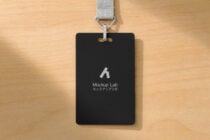 Black ID badge mockup with gray fabric lanyard on wooden surface