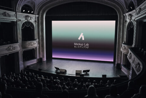 Classical theater hall with ornate ceiling where crowd watches screen showing gradient background design mockup