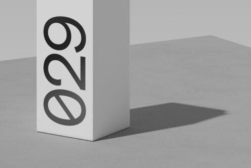 White box mockup with bold black geometric logo casting sharp shadow on gray surface