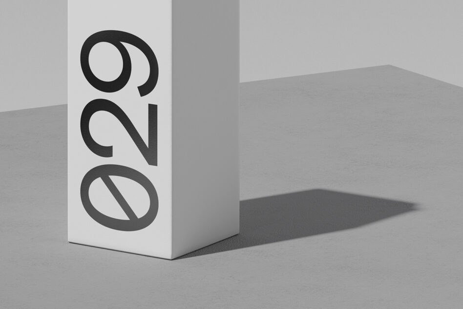 White box mockup with bold black geometric logo casting sharp shadow on gray surface