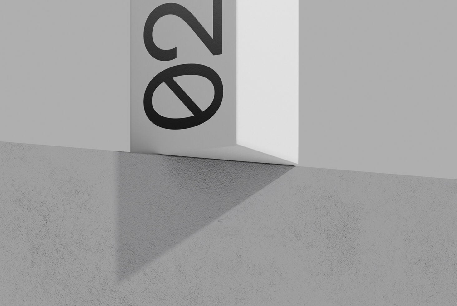 Logo mockup on folded white paper with concrete floor, bold black letterforms casting shadows