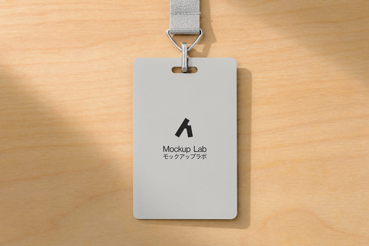 ID badge mockup with gray fabric lanyard on wooden background
