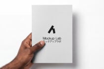 Hand holding light gray card displaying black Mockup Lab symbol below text