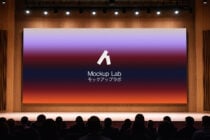 Theater projection screen showing purple to orange gradient with audience below