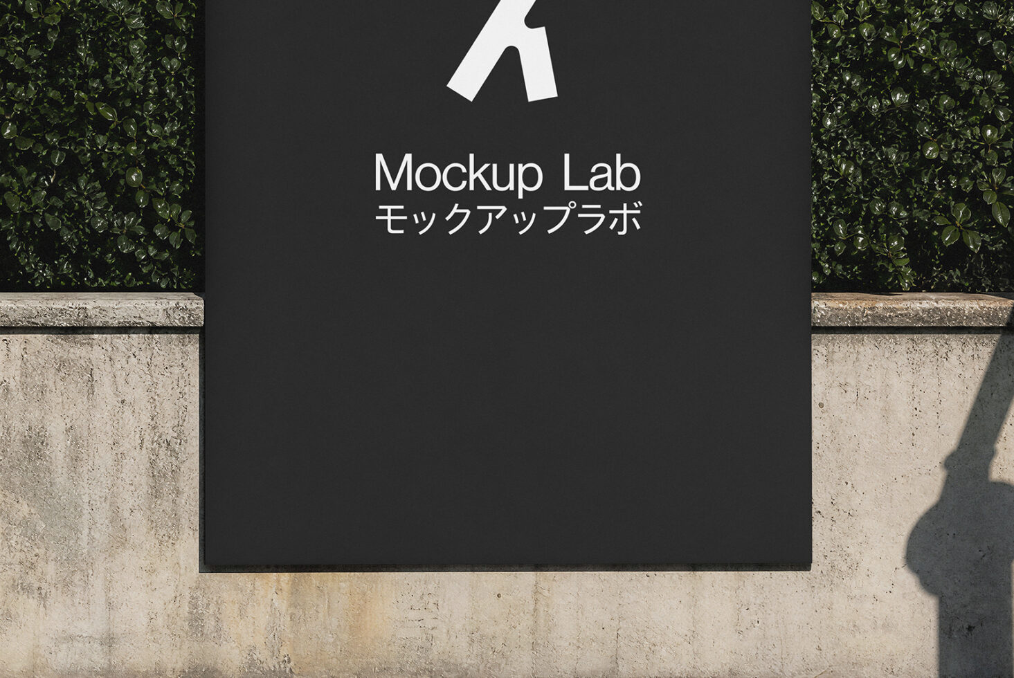 Outdoor storefront sign mockup with dark panel, white logo, bilingual text, concrete base, green hedges, natural shadow
