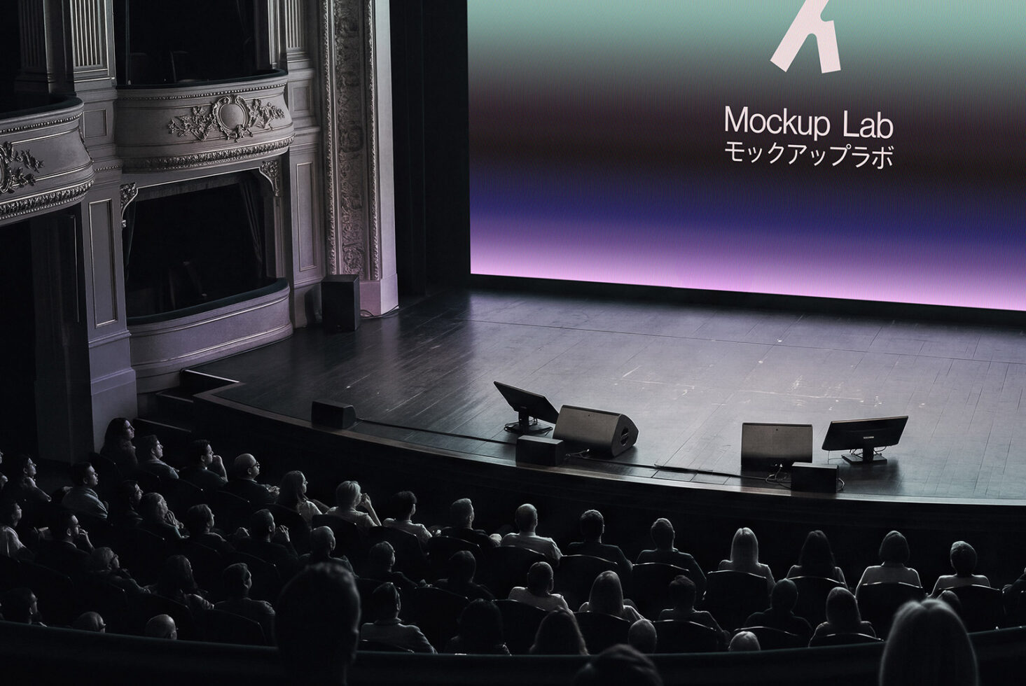 Grand ornate theater auditorium filled with audience watching stage display showing Mockup Lab branding