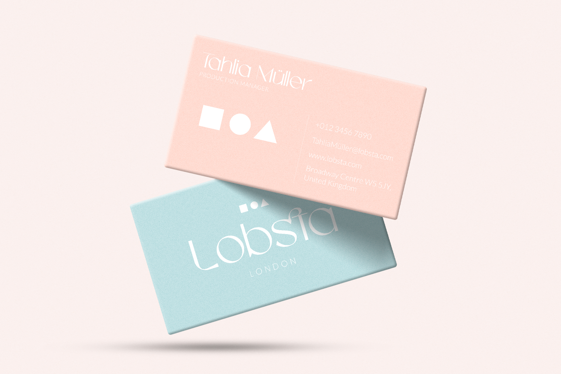 Two business cards stacked, one peach one teal with minimal geometric shapes