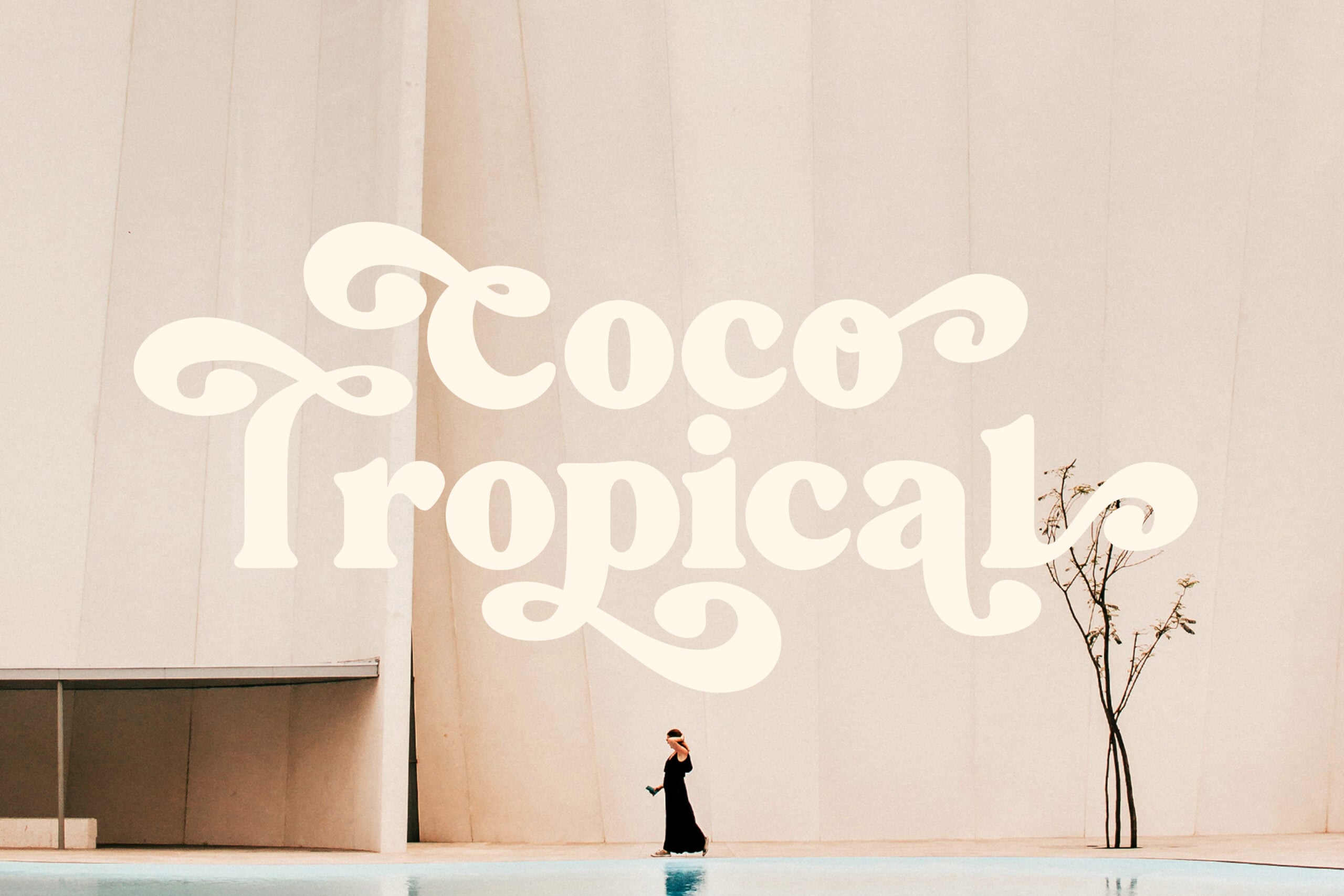 Woman in black dress walking by massive cream serif typography reading Coco Tropical
