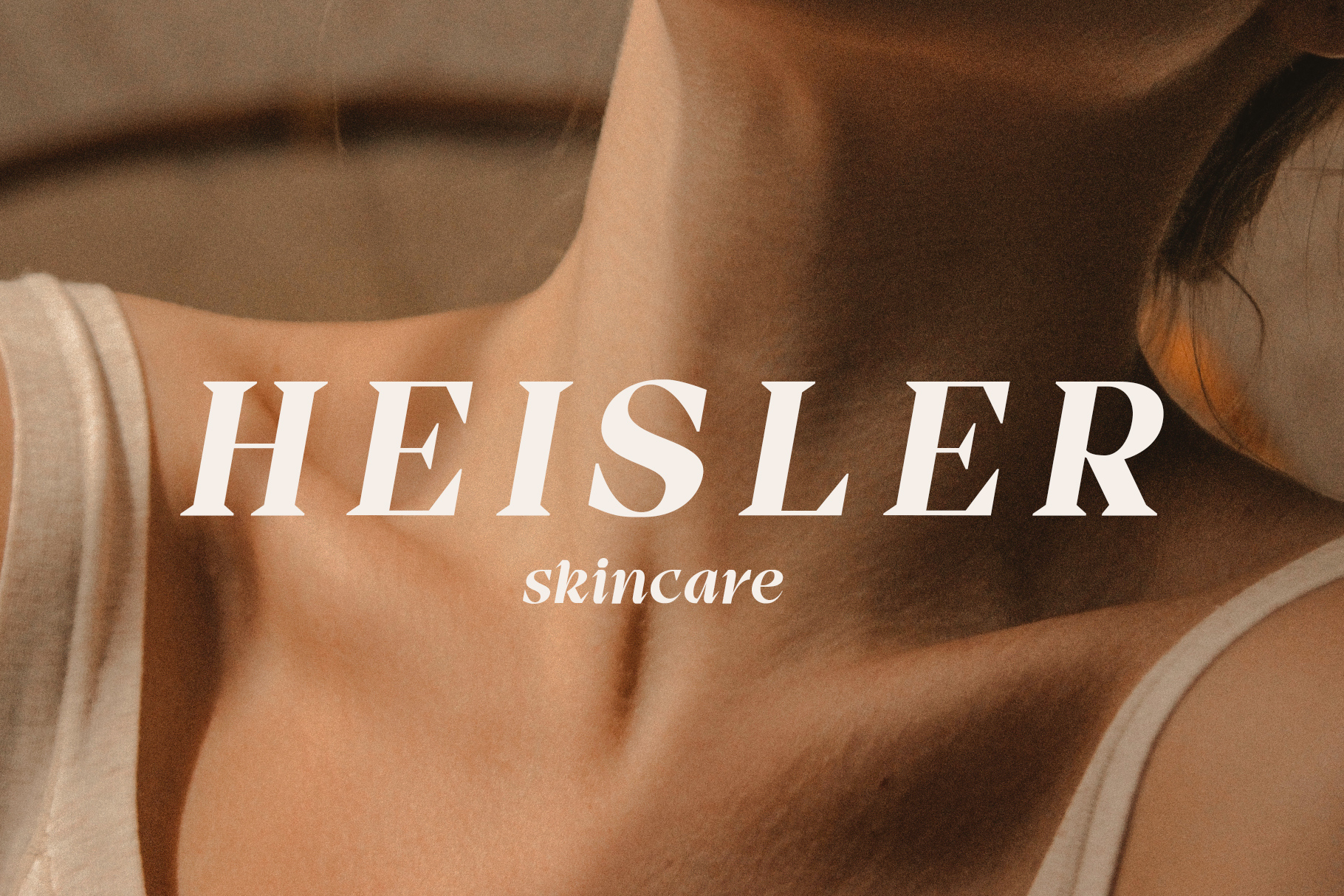 Skincare branding mockup with Heisler text overlaid on close-up of woman's shoulder