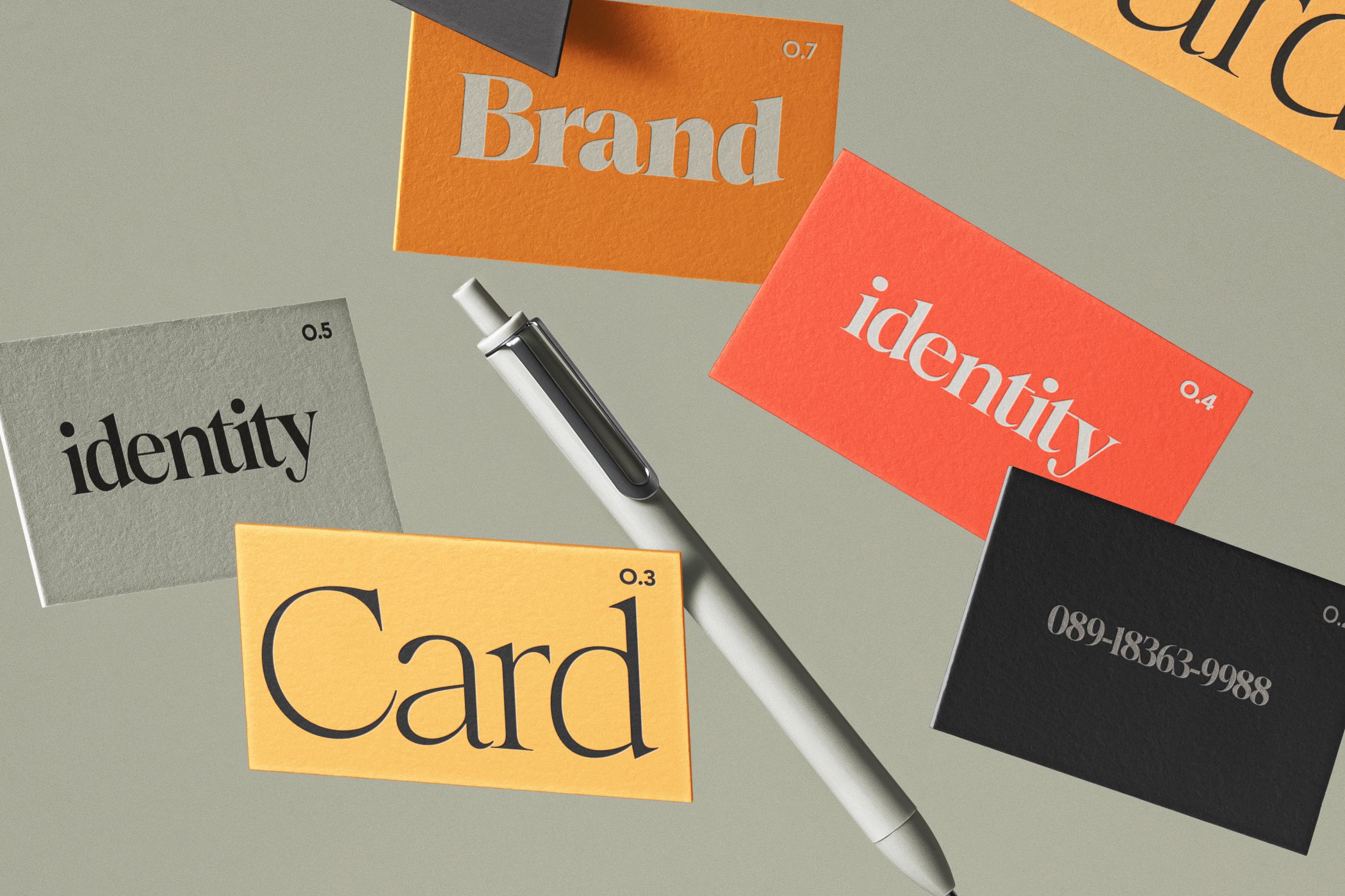 Brand identity mockup showing scattered business cards, pen, colored stationery pieces