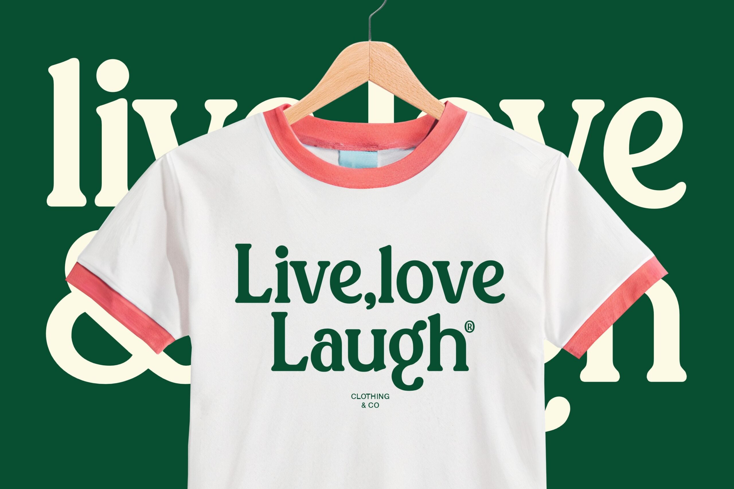 White tee with coral ringer collar displaying live love laugh text on hanger