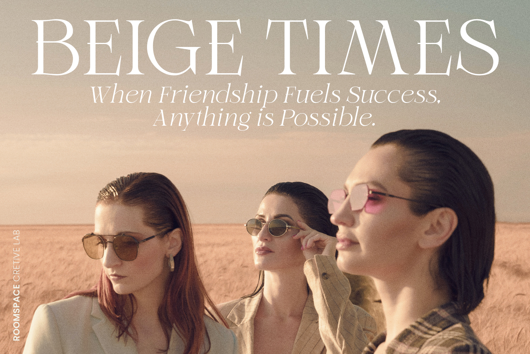 Three women in sunglasses standing in a desert landscape with beige tones