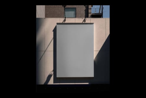 Blank poster mockup on concrete building facade with sharp shadow overlay