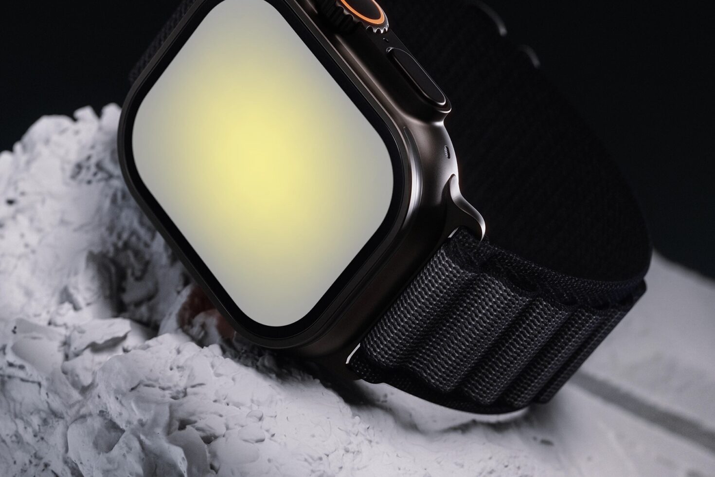 Smartwatch with black case on white sandy surface, blank screen ready for design mockup