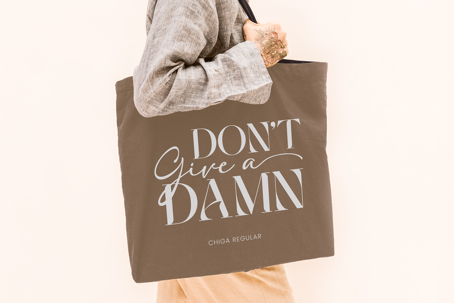 Brown tote bag mockup with Don't Give Damn text in Chiga Regular font