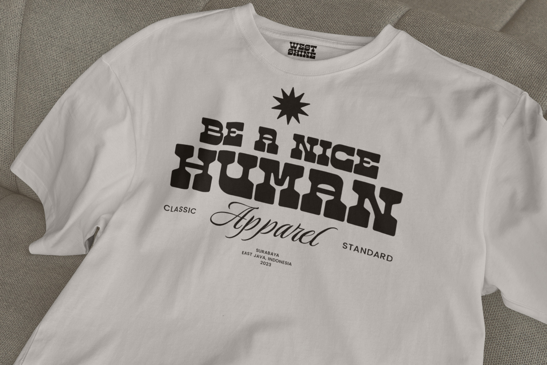 White t-shirt with black retro typography reading be a nice human apparel