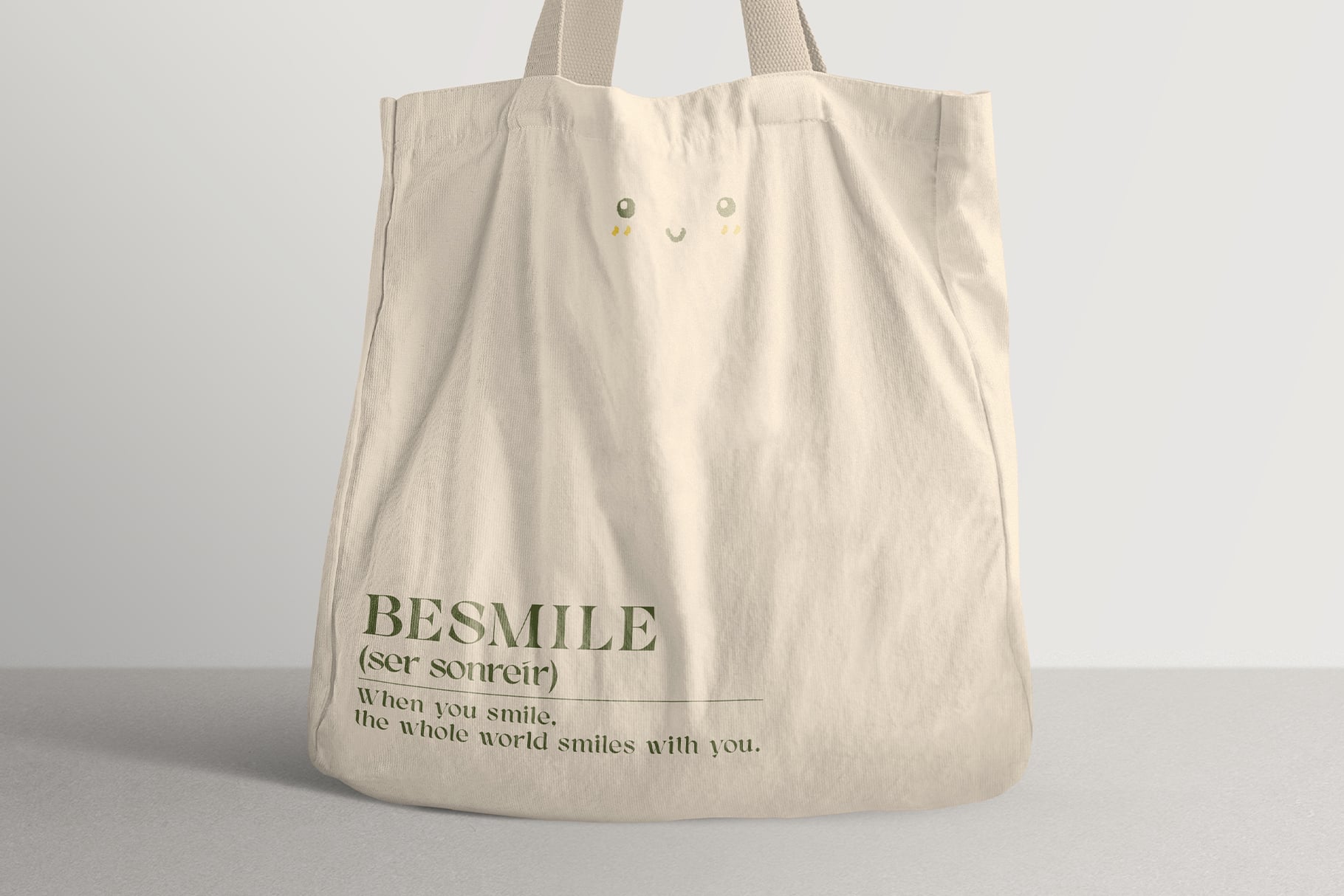 Canvas tote bag mockup with serif typography, smiley face design