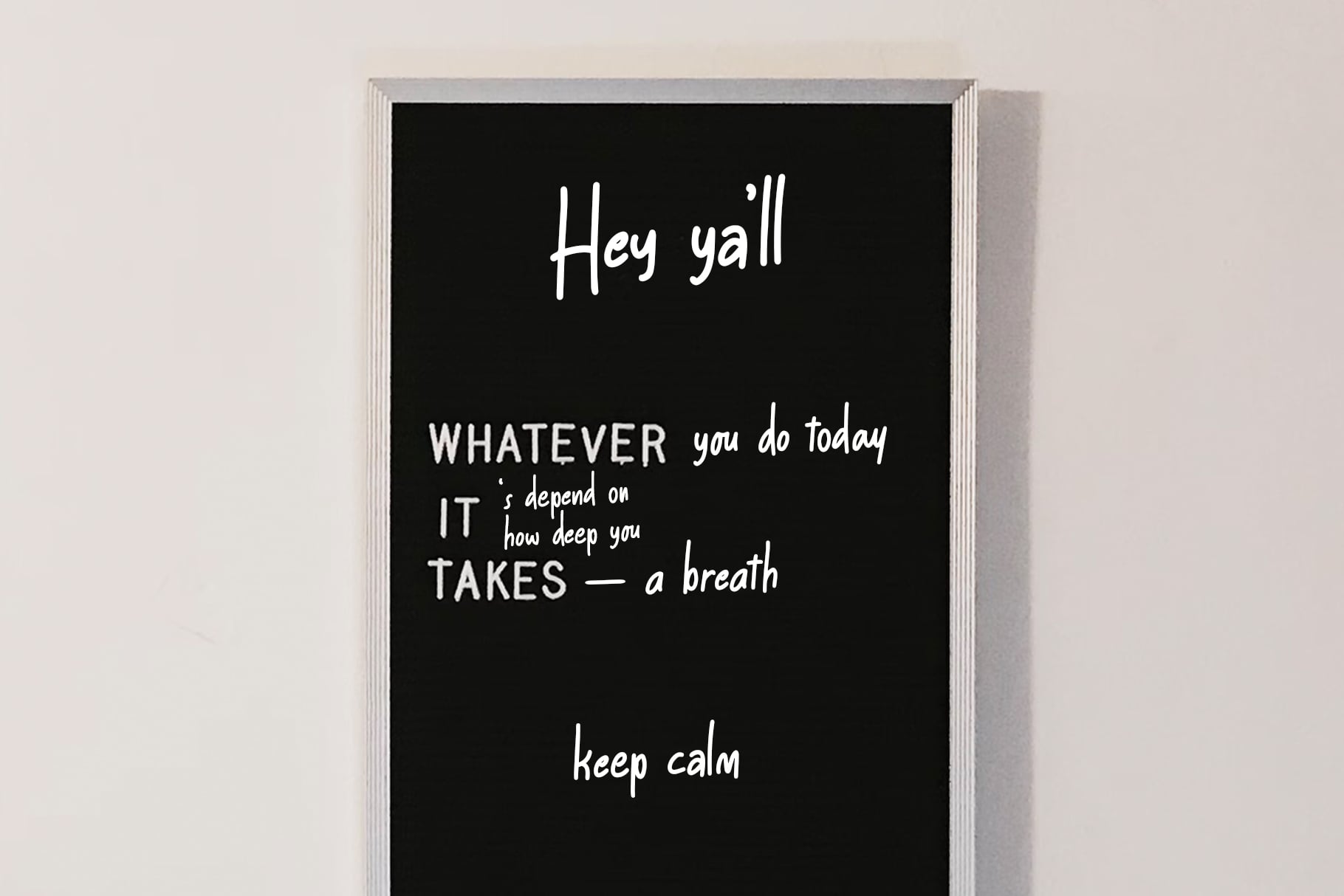Silver framed black board with handwritten motivational text saying hey yall, whatever you do today, keep calm