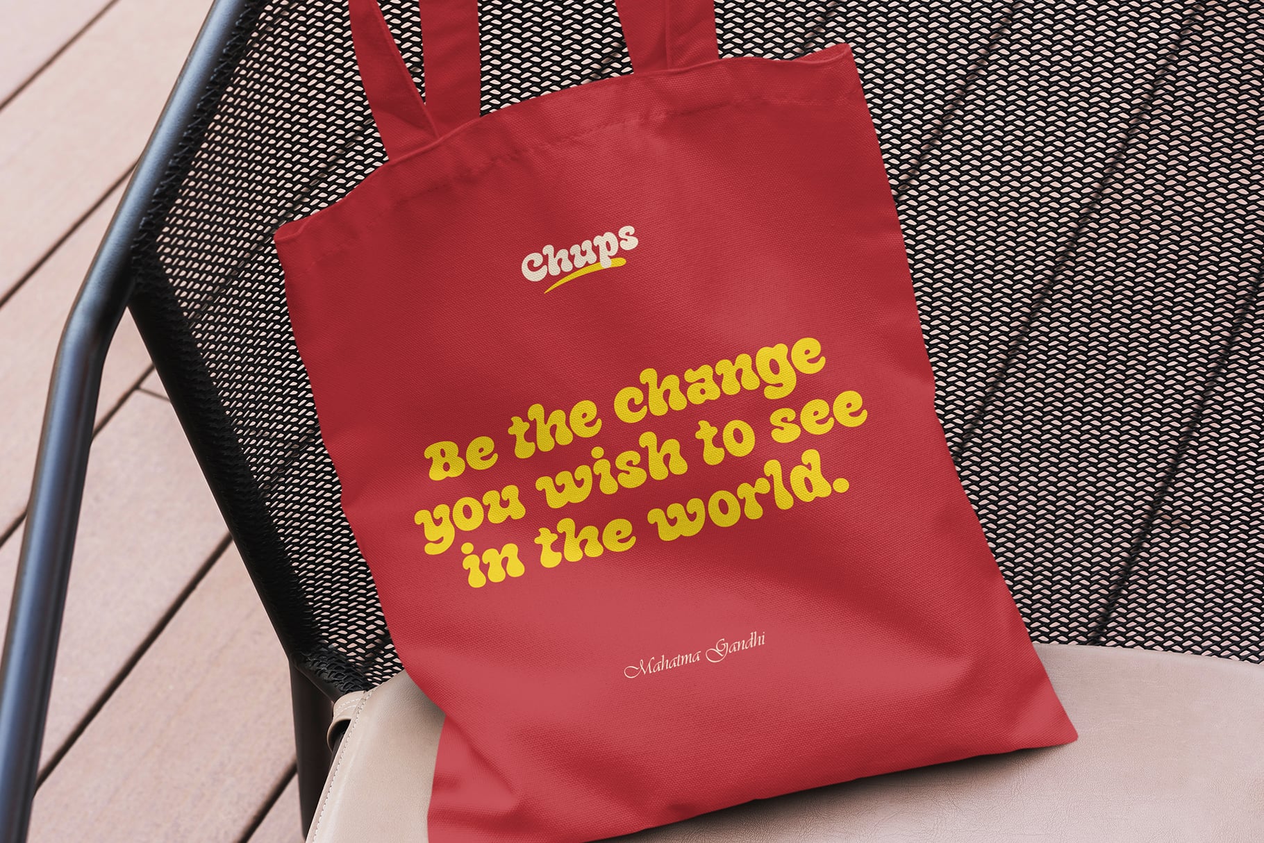 Red tote bag with Chups yellow text saying be the change you wish to see