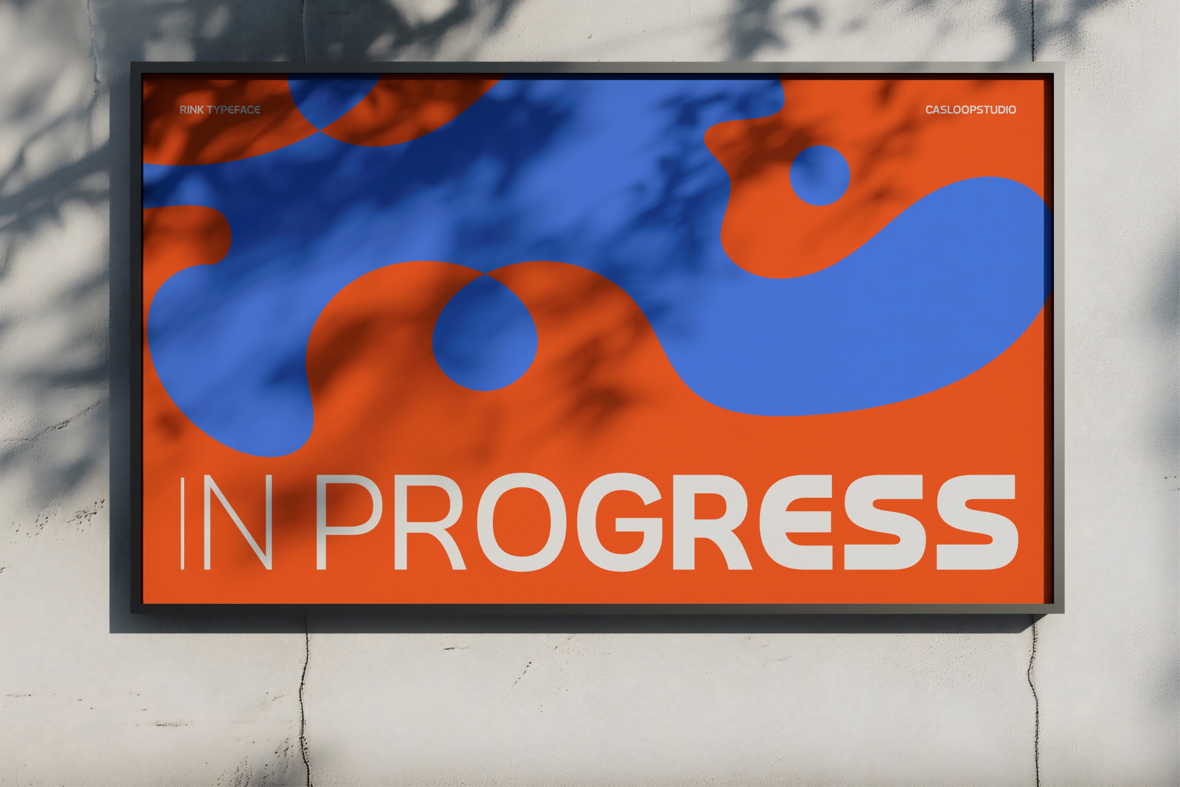 Digital billboard displaying IN PROGRESS text with flowing blue orange shapes