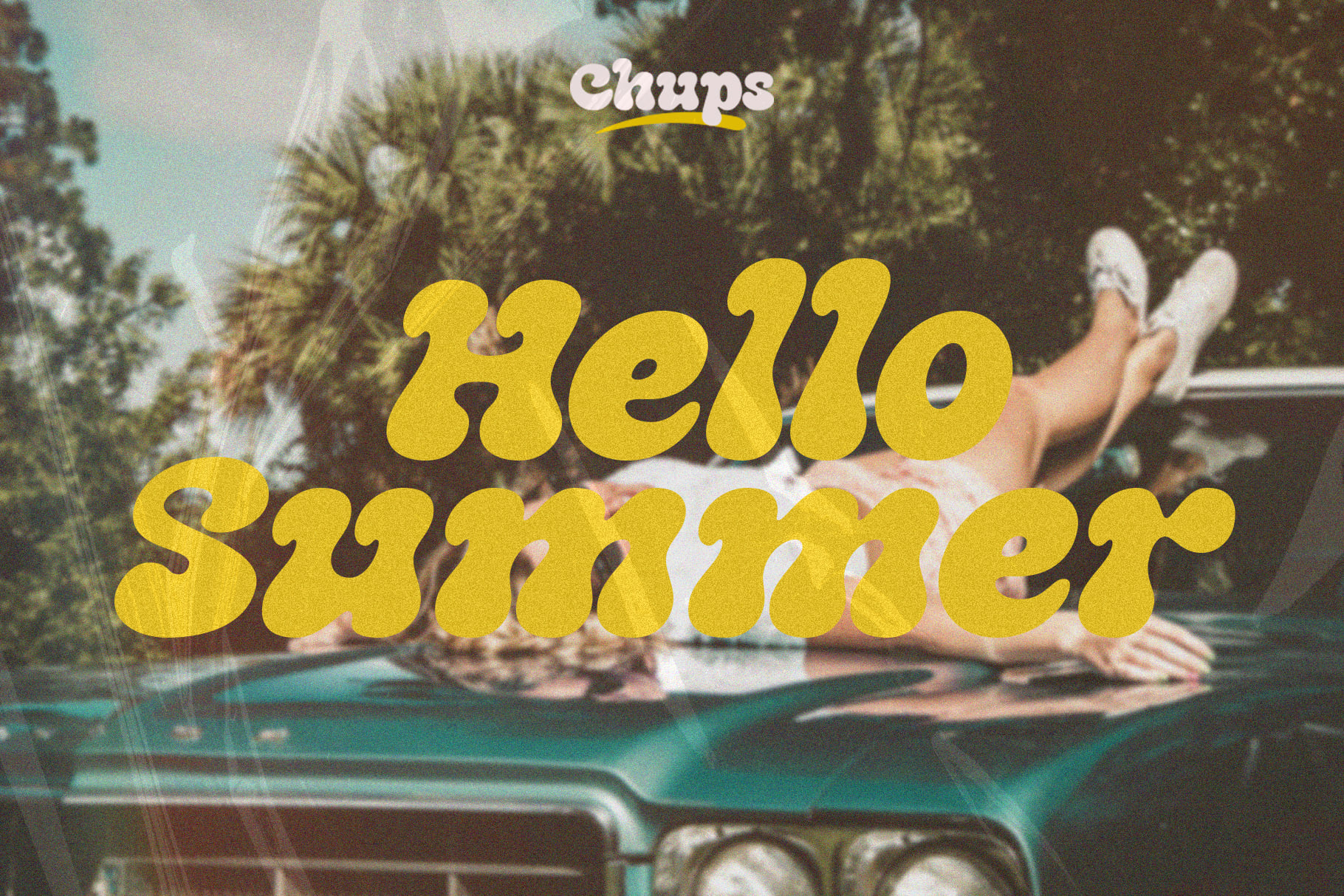 Retro car interior with feet on dashboard overlaid with large yellow hello summer text among palm trees