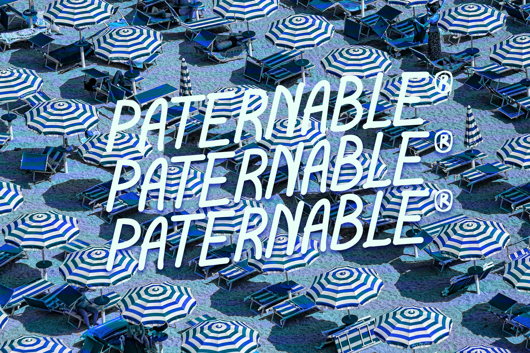 Overhead shot of beach umbrellas with white neon text overlay reading "Papernabille"
