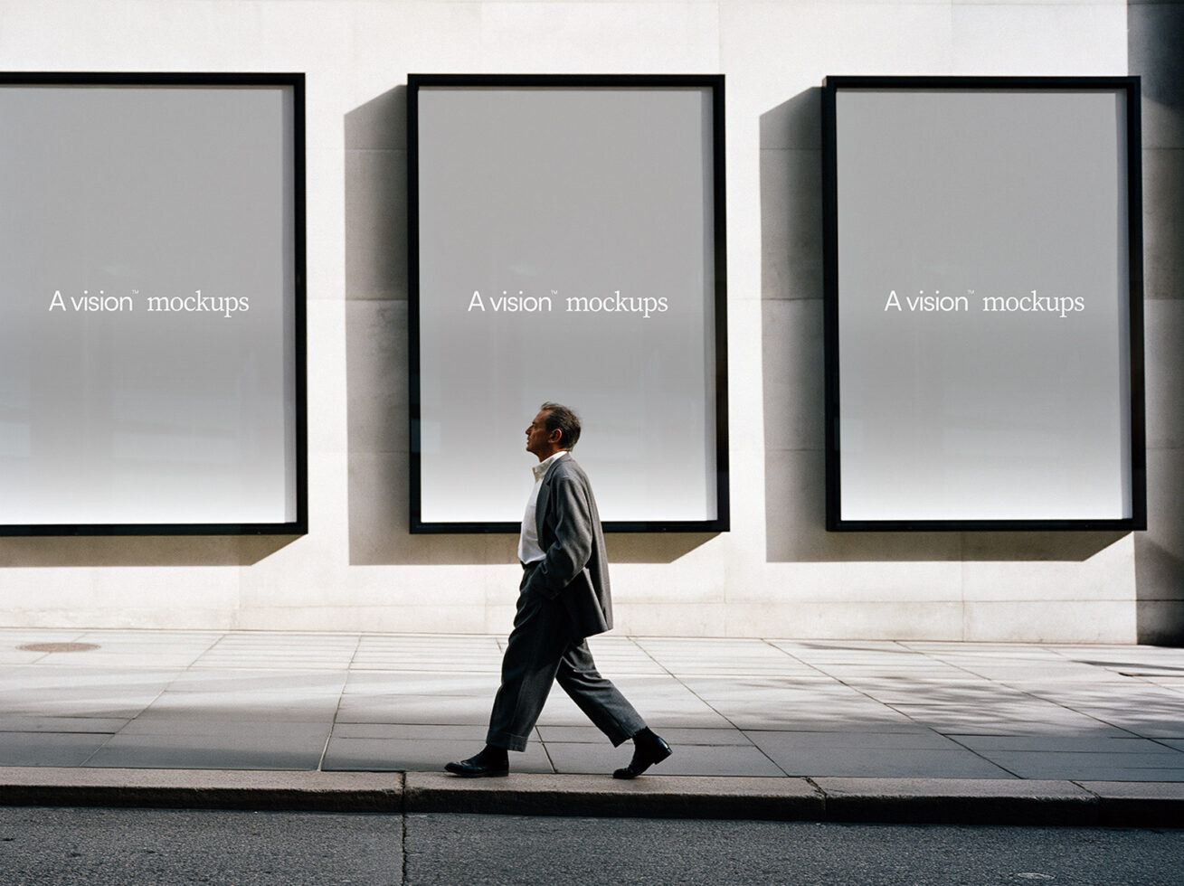 Three empty framed displays on white wall with person in motion
