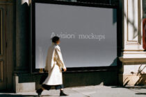 Large storefront window mockup with person walking past in cream coat
