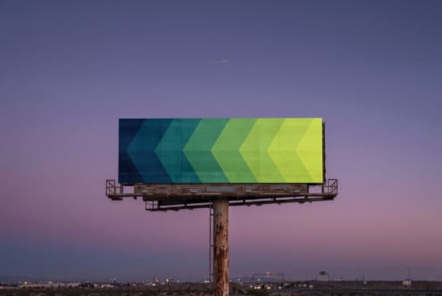 Vintage billboard displaying gradient chevron design teal to yellow