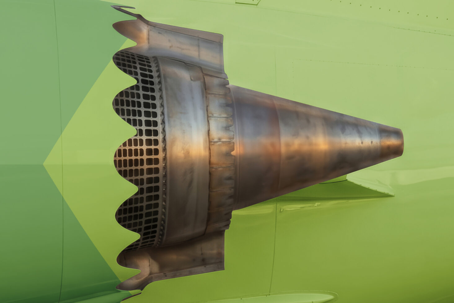Jet engine turbine mounted on lime green wall viewed from side angle