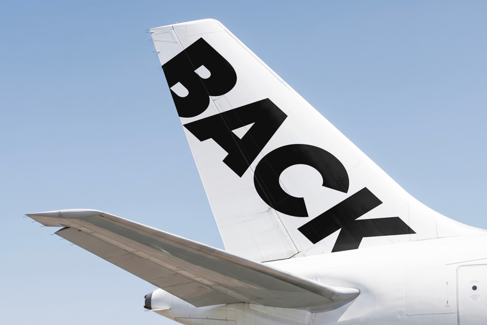 White airplane tail showing black letter R with geometric cutout design