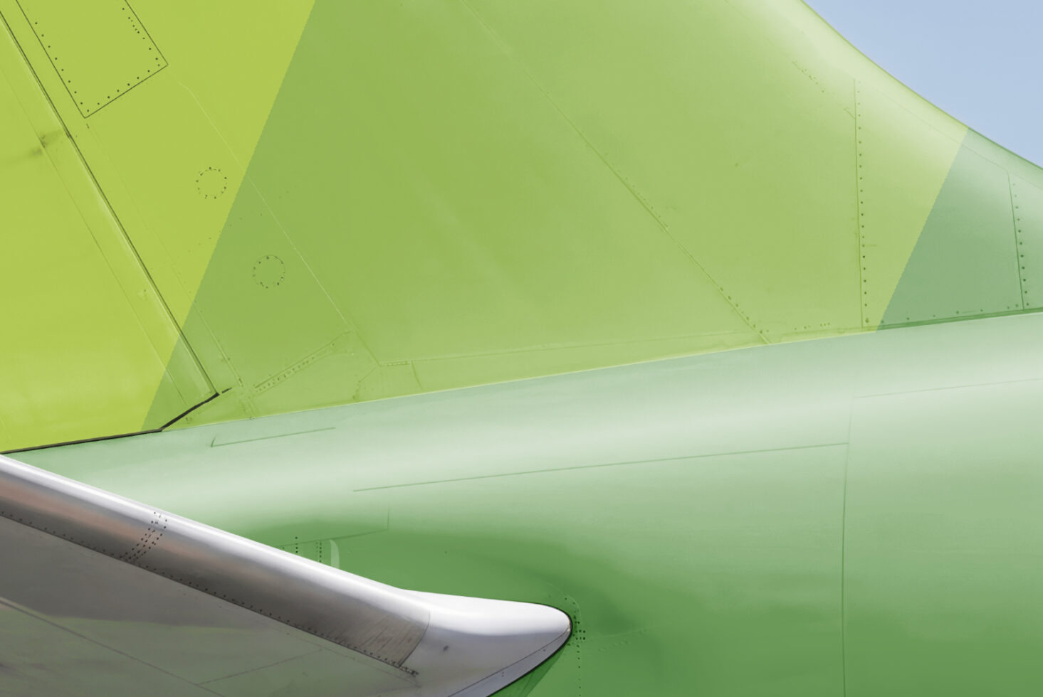 Close up of bright lime aircraft wing with riveted panel details