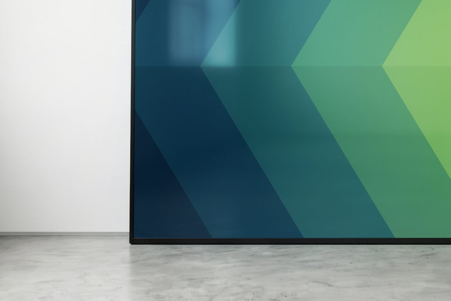 Monitor displaying dark blue to lime chevron gradient on concrete floor