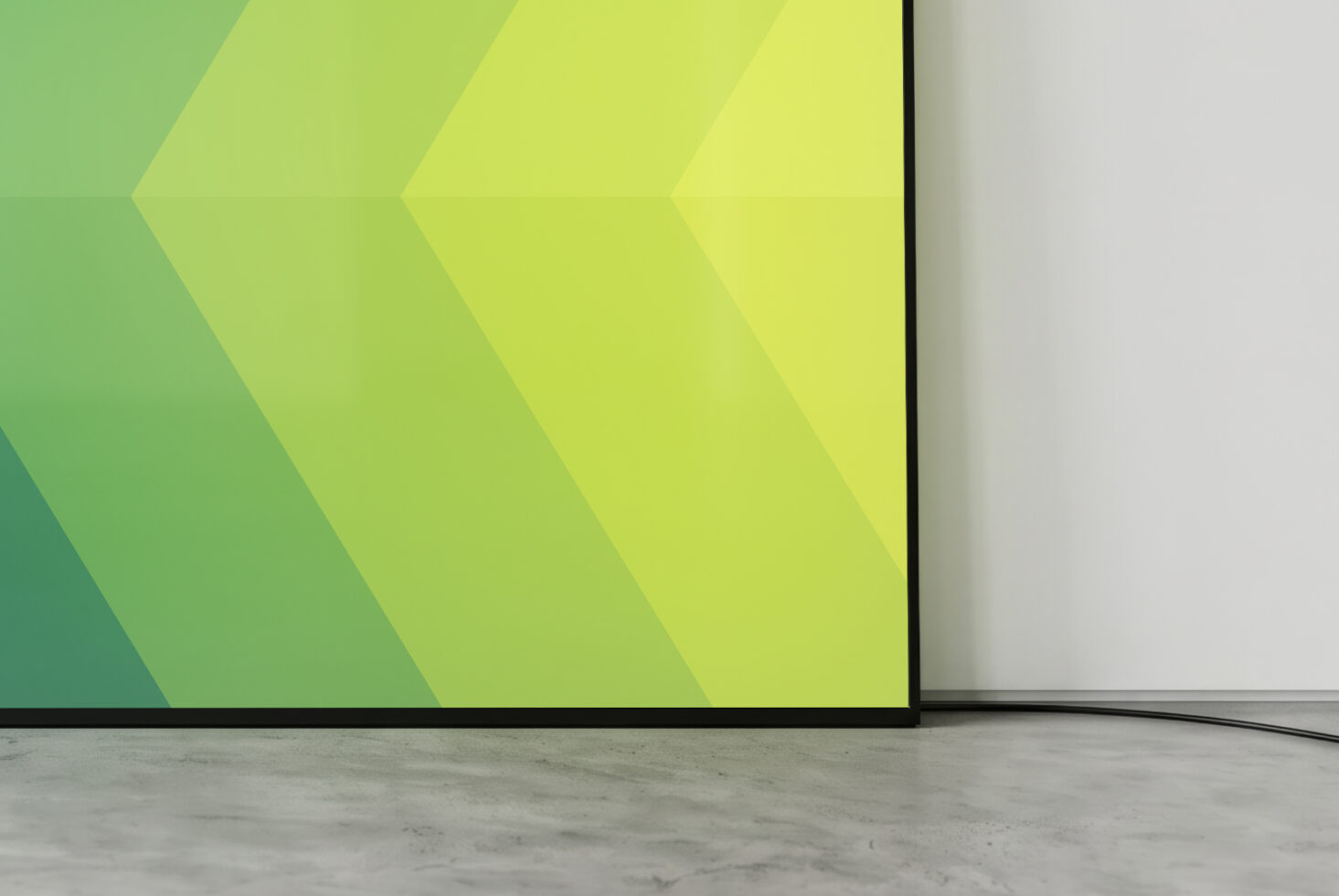 Large monitor screen showing lime chevron pattern on concrete floor