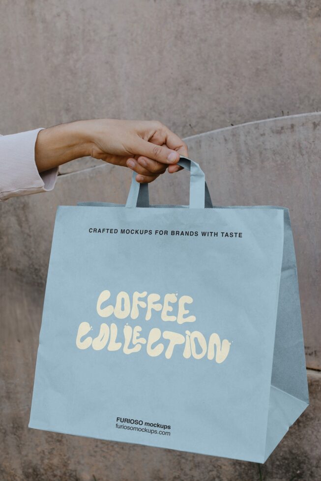 Blue tote bag being held displaying coffee collection branding