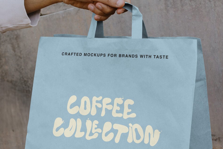 Hand holding light blue tote bag with Coffee Collection text in cream lettering