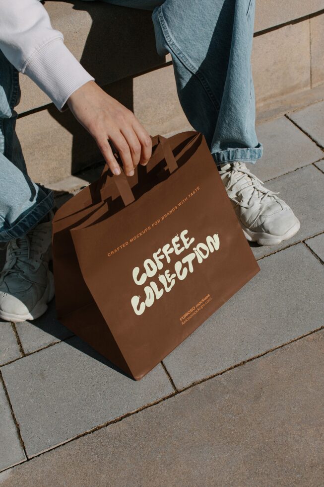 Overhead shot of brown kraft bag being held with Coffee Collection design visible