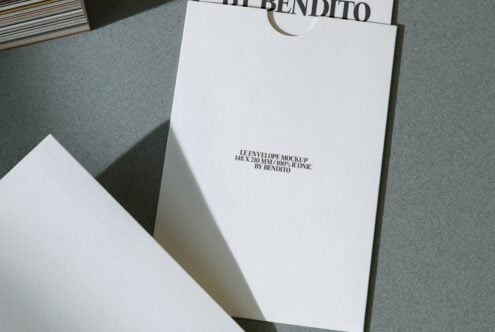 White envelope mockup 148x210mm on gray surface with minimal branding