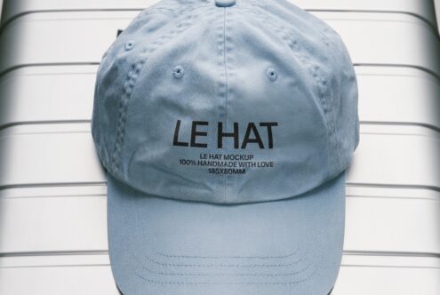Sky blue baseball cap front view with embroidered branding on striped backdrop
