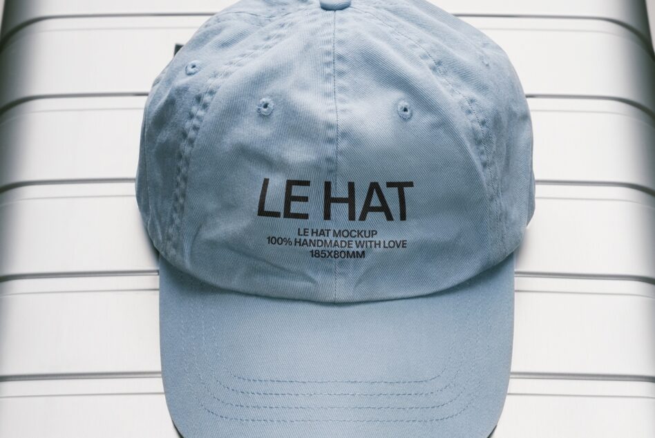 Sky blue baseball cap front view with embroidered branding on striped backdrop
