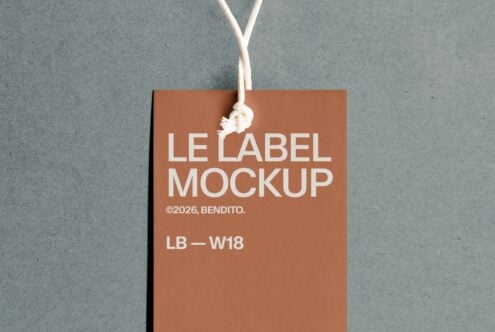 Rust colored hang tag with white text hanging on gray concrete wall